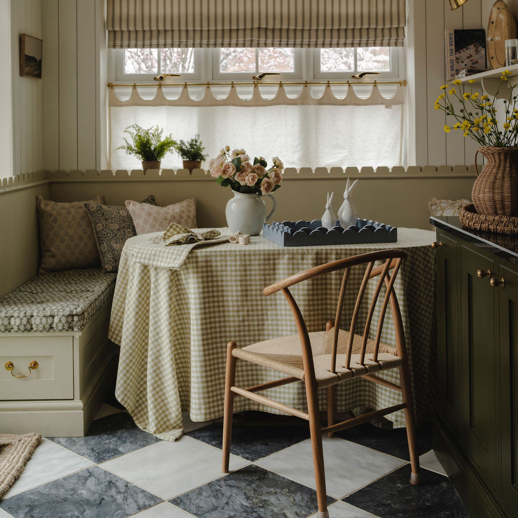 Nook with checkered tablecloth, wooden chair, and decorative elements.