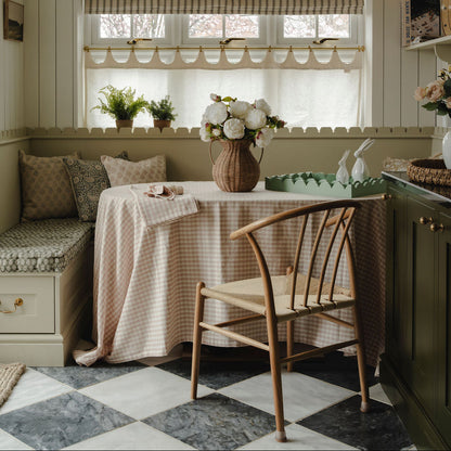 Nook with a checkered tablecloth, wooden chair, and decorative elements.